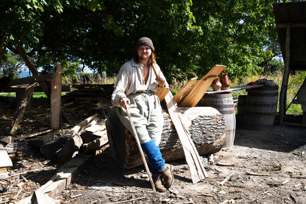 039 A re-enactor poses at his worksite in the 17th century English village.jpg